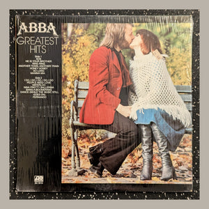 ABBA - Greatest Hits, actual copy, front: kissing couple; title column on left, complete physical edges visible in a matching light frame